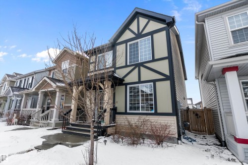 The property features a Tudor Revival style exterior with light-colored siding and dark trim - 7776 Eifert Crescent Nw, Edmonton, AB - Outdoor With Facade