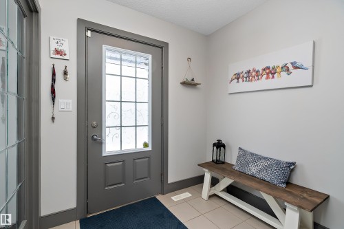 Entryway featuring a grey front door with decorative glass inserts, light grey walls, and tiled flooring - 7776 Eifert Crescent Nw, Edmonton, AB - Indoor Photo Showing Other Room