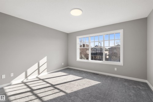 This room features a window providing natural light, light gray walls, and gray carpeting - 4016 Allan Crescent, Edmonton, AB - Indoor Photo Showing Other Room