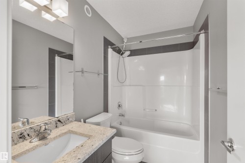 Bathroom featuring a vanity with a light-colored granite countertop, a white sink, and a chrome faucet - 4016 Allan Crescent, Edmonton, AB - Indoor Photo Showing Bathroom
