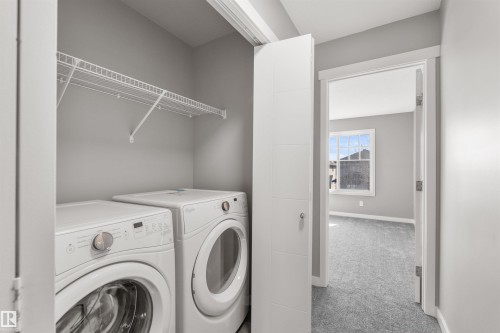 This utility area features a clothes washer and dryer, with a wire shelf for storage - 4016 Allan Crescent, Edmonton, AB - Indoor Photo Showing Laundry Room