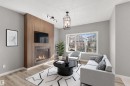 The living area features a fireplace with a wood-paneled surround, light-colored flooring, and a large window providing views of the neighborhood - 4016 Allan Crescent, Edmonton, AB  - Indoor Photo Showing Living Room With Fireplace 