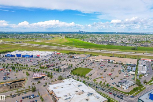 Aerial view of the surrounding area featuring commercial buildings with parking lots, an expansive green field, and a highway - 4016 Allan Crescent, Edmonton, AB - Outdoor With View