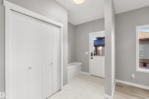 Entryway featuring light grey walls, white bi-fold doors, and a window providing natural light - 4016 Allan Crescent, Edmonton, AB - Indoor Photo Showing Other Room