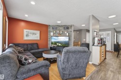The living area features recessed lighting, a stone accent wall, and wood flooring - 