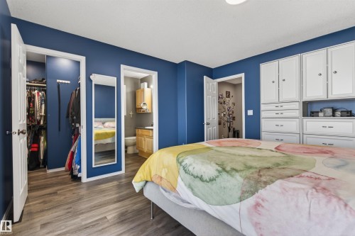 The room features wood-look flooring, blue walls, a white door, and white built-in cabinetry with drawers - #12 61212  Rr 463, Rural Bonnyville M.D., AB - Indoor Photo Showing Bedroom