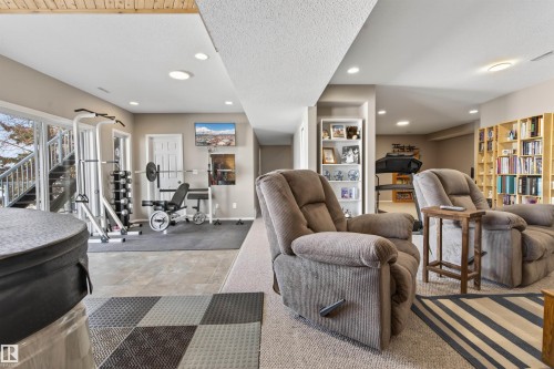 Versatile recreation space featuring recessed lighting, a sliding glass door, and a built-in shelving unit - #12 61212  Rr 463, Rural Bonnyville M.D., AB - Indoor Photo Showing Gym Room