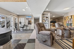Versatile recreation space featuring recessed lighting, a sliding glass door, and a built-in shelving unit - 