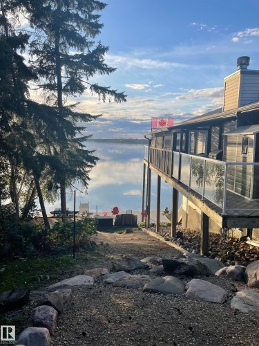 The property features an extensive deck with glass railings, providing clear views of the water - #12 61212  Rr 463, Rural Bonnyville M.D., AB - Outdoor With View