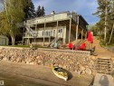 Multi-level residence featuring extensive decking, glass panel railings, and a walk-out lower level - #12 61212  Rr 463, Rural Bonnyville M.D., AB  - Outdoor With Body Of Water 
