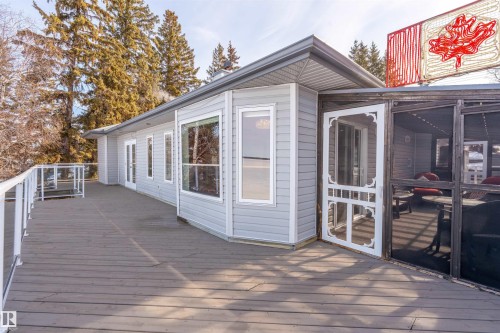 Expansive wooden deck providing outdoor space, featuring a glass railing and a screened-in porch area - #12 61212  Rr 463, Rural Bonnyville M.D., AB - Outdoor With Exterior