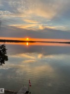 Stunning water views from the property, featuring a private dock and vibrant sunset - 