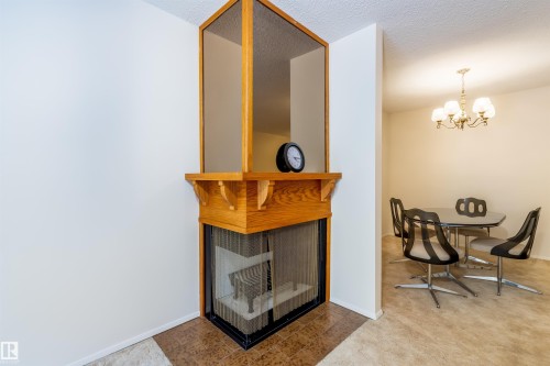 This property features a corner fireplace with a wooden mantelpiece and a decorative wooden surround - 108 Forest Grove, St. Albert, AB - Indoor Photo Showing Other Room With Fireplace
