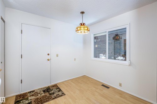 This room features light wood flooring, white walls, and a large window providing natural light - 108 Forest Grove, St. Albert, AB - Indoor Photo Showing Other Room