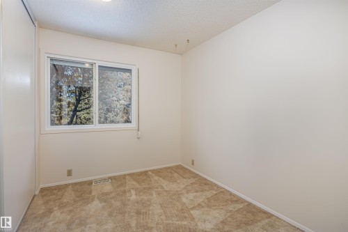 This room features a window providing natural light, warm neutral wall paint, and patterned carpeting - 108 Forest Grove, St. Albert, AB - Indoor Photo Showing Other Room