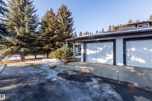 The property features a two-car garage with white panel doors and a textured exterior finish - 108 Forest Grove, St. Albert, AB - Outdoor