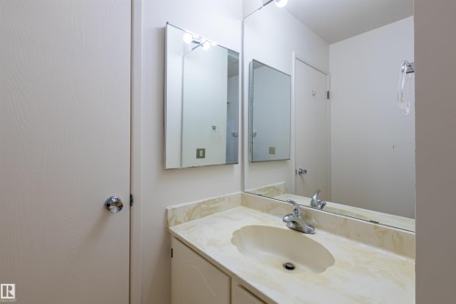 Bathroom vanity with an integrated sink, polished chrome faucet, and a large mirror - 108 Forest Grove, St. Albert, AB - Indoor Photo Showing Bathroom