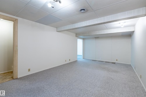 Spacious room featuring light grey carpeting, white walls, and a drop ceiling with recessed lighting - 108 Forest Grove, St. Albert, AB - Indoor Photo Showing Other Room