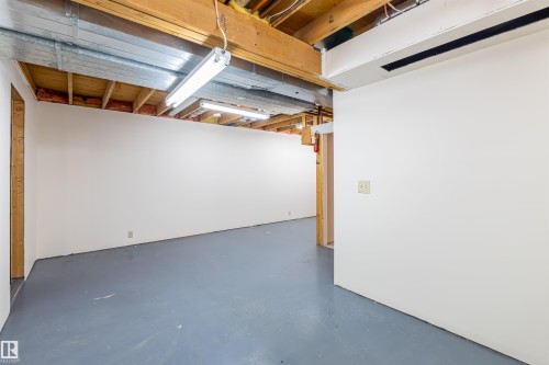 The property features a spacious unfinished room with painted concrete flooring and exposed ceiling joists - 108 Forest Grove, St. Albert, AB - Indoor Photo Showing Basement