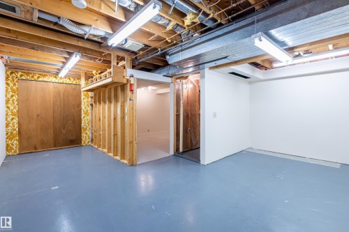 The property features an unfinished basement with painted concrete floors and exposed ceiling joists - 108 Forest Grove, St. Albert, AB - Indoor Photo Showing Basement