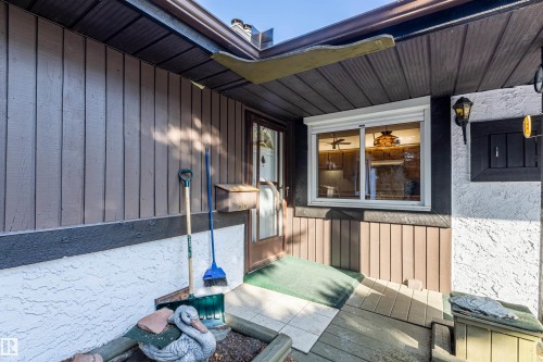 The property features exterior wood siding, a front entry door with a glass insert, and a window with a roll-down shutter - 108 Forest Grove, St. Albert, AB - Outdoor With Exterior