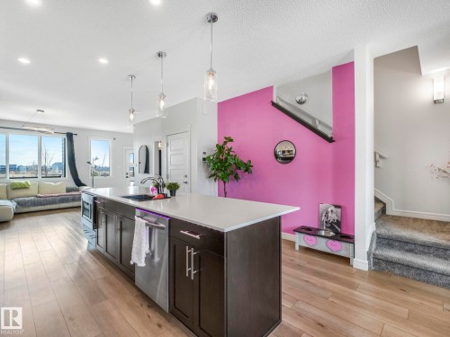 The property features an open-concept living area with light-toned hardwood flooring throughout - 2636 192 Street, Edmonton, AB - Indoor Photo Showing Kitchen With Upgraded Kitchen