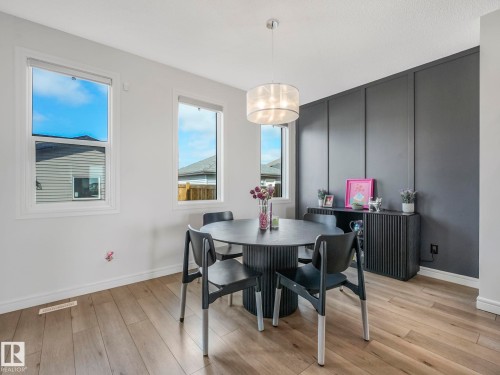 The dining area features light wood flooring, white walls, and two windows providing natural light - 2636 192 Street, Edmonton, AB - Indoor Photo Showing Dining Room