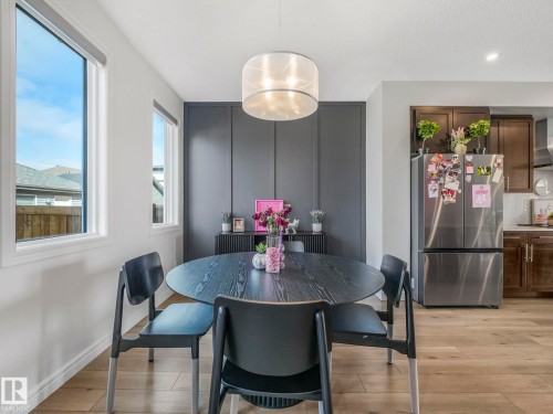 The dining area features light hardwood flooring, a contemporary ceiling light fixture, and a dark accent wall - 2636 192 Street, Edmonton, AB - Indoor Photo Showing Dining Room
