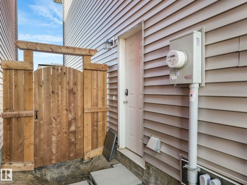 The property features a wood plank fence with an arched gate, providing a private outdoor area - 2636 192 Street, Edmonton, AB - Outdoor