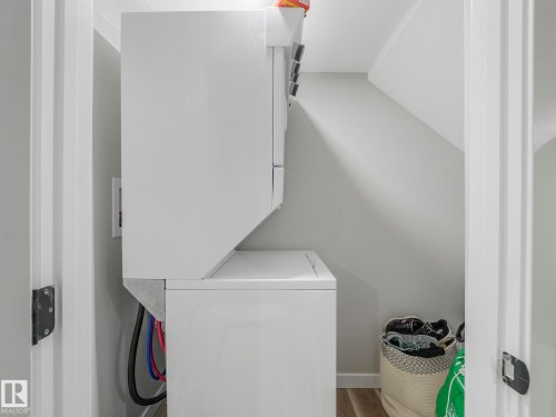 Dedicated laundry space featuring a white stacked washer and dryer unit - 2636 192 Street, Edmonton, AB - Indoor Photo Showing Laundry Room