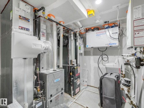 The property features a utility room with exposed ductwork, piping, and various mechanical systems - 2636 192 Street, Edmonton, AB - Indoor Photo Showing Basement