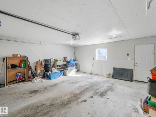 This garage features a concrete floor, white walls, and a white entrance door - 2636 192 Street, Edmonton, AB - Indoor Photo Showing Garage