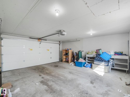 The property features a garage with a white garage door, concrete flooring, and overhead lighting - 2636 192 Street, Edmonton, AB - Indoor Photo Showing Garage