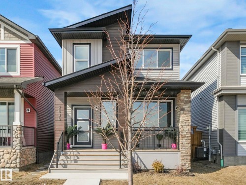 This property features modern architectural design with a dark grey and light grey exterior, complemented by a prominent dark-framed front door with frosted glass panels - 2636 192 Street, Edmonton, AB - Outdoor