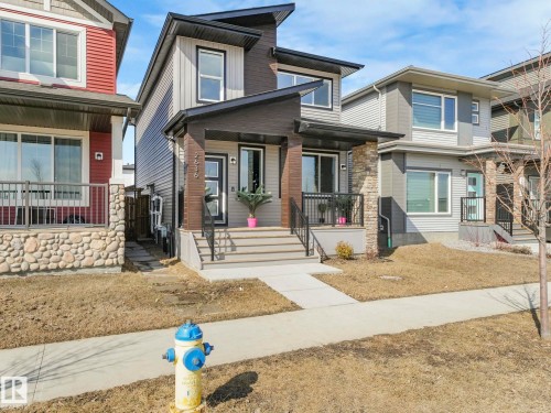 The property features a modern exterior with a grey and dark brown facade, stone column accents, and a covered front entrance - 2636 192 Street, Edmonton, AB - Outdoor With Deck Patio Veranda With Facade