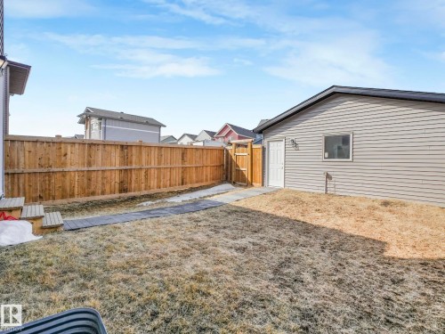The property features a private yard with a wooden fence and a detached garage with siding and a window - 2636 192 Street, Edmonton, AB - Outdoor