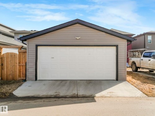 The property features a detached garage with light gray siding and a white garage door, complemented by a concrete driveway - 2636 192 Street, Edmonton, AB - Outdoor With Exterior
