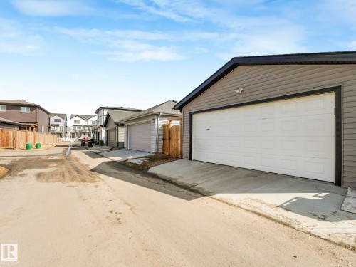 Detached garage with horizontal siding, a white garage door, and a concrete driveway - 2636 192 Street, Edmonton, AB - Outdoor
