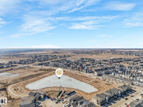 Aerial view of the property's location within a developed community, featuring a pond with a partially frozen surface and surrounding homes - 2636 192 Street, Edmonton, AB - Outdoor With View