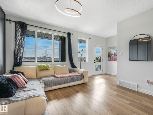 The living area features hardwood floors and large windows providing abundant natural light - 2636 192 Street, Edmonton, AB - Indoor Photo Showing Living Room