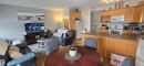 Open concept living area with light wood cabinetry, white appliances, and a breakfast bar - 5514 49 Street, Vegreville, AB  - Indoor 