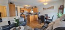 Open concept living area featuring a kitchen with wood cabinetry, a dining area with a round table, and a living room with wood flooring - 5514 49 Street, Vegreville, AB  - Indoor Photo Showing Other Room 