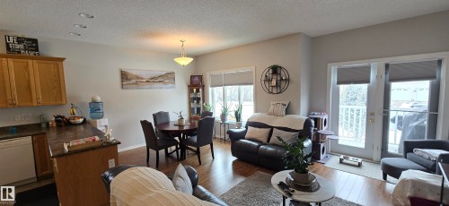 This open concept living space features hardwood flooring, recessed lighting, and a kitchen with oak cabinetry and a dishwasher - 5514 49 Street, Vegreville, AB - Indoor