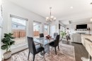 This inviting dining area features large windows, dark hardwood flooring, and a contemporary chandelier - 922 173A Street, Edmonton, AB  - Indoor Photo Showing Dining Room 