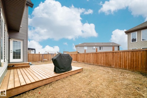 The property features a wooden deck with stairs providing outdoor living space, a fenced yard, and a rear entrance with a glass-paned door - 922 173A Street, Edmonton, AB - Outdoor