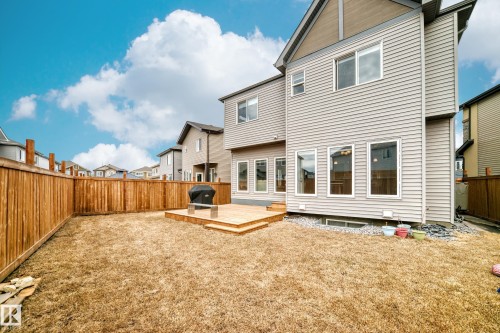 The property features a spacious backyard with a wooden fence and a multi-level wooden deck - 922 173A Street, Edmonton, AB - Outdoor