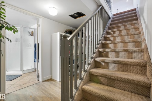 The property features a staircase with carpeted treads and risers, accompanied by a painted wooden railing and banister - 101 Westridge Road, Edmonton, AB - Indoor Photo Showing Other Room