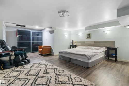 This spacious room features light-colored walls, wood-look flooring, and recessed ceiling lighting - 101 Westridge Road, Edmonton, AB - Indoor Photo Showing Bedroom