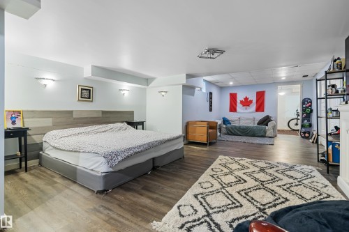 The property features light-colored walls and dark wood-look flooring throughout - 101 Westridge Road, Edmonton, AB - Indoor Photo Showing Bedroom