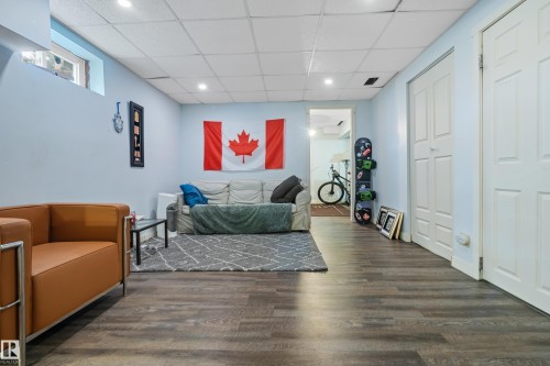 This versatile living space features durable wood-look flooring, a drop ceiling with recessed lighting, and light blue walls - 101 Westridge Road, Edmonton, AB - Indoor